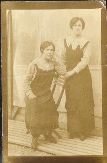 Ritratto di due donne, una seduta ed una in piedi, in abiti da lavoro. - copertina